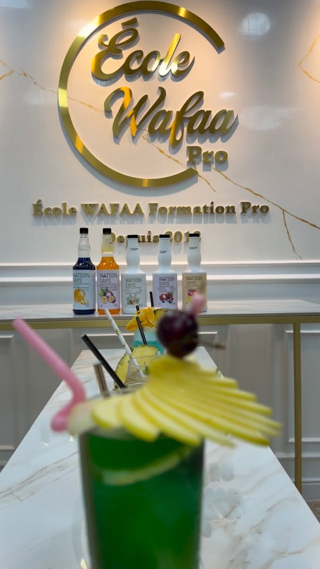 Cocktails sans alcool dressés devant le mur d'accueil doré de l'École Wafaa